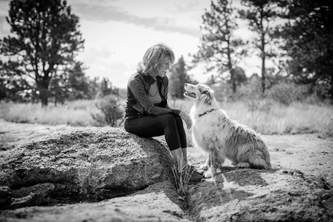 service dog certification canada — woman sitting on rock with dog