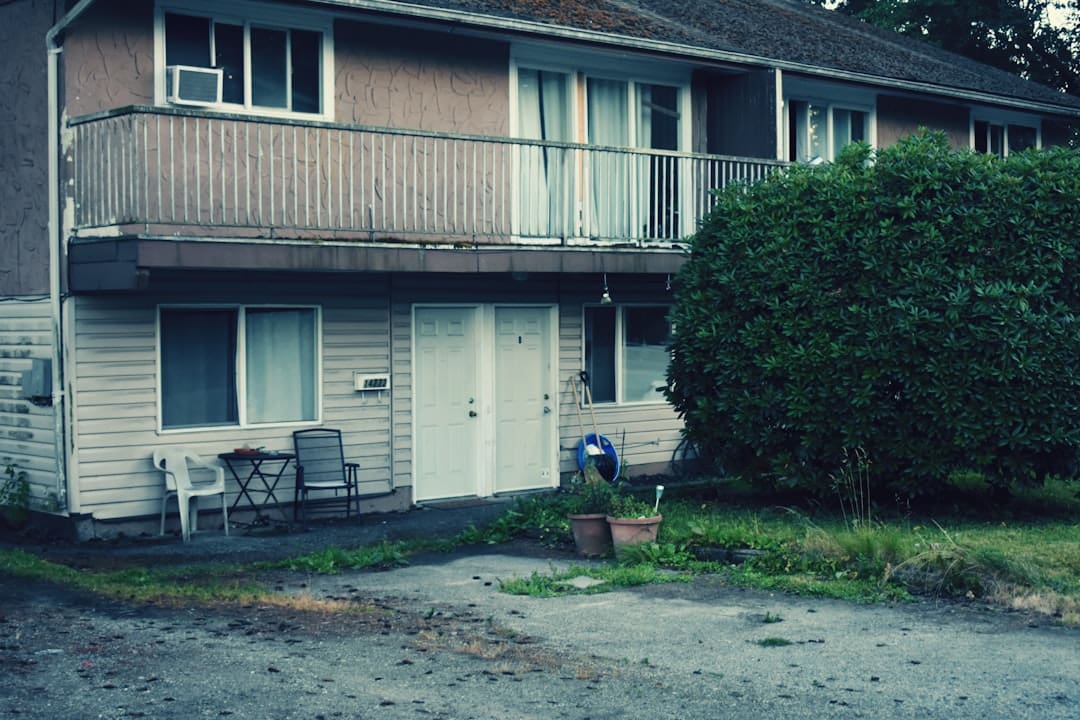 support animal rights — A two story apartment building with a car parked in front of it